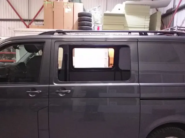 Window aperture cut into the side panel of a grey van
